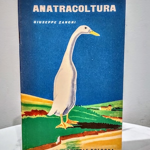 May include: A vintage book cover with a blue background and a white duck illustration. The title of the book is "ANATRACOLTURA" and the author is "GIUSEPPE ZANONI". The book cover also features a green field and a small building in the background.