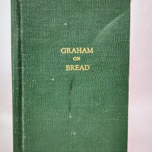 May include: A green book with the title "GRAHAM ON BREAD" in gold lettering.