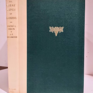 May include: The Great Wines of Germany book cover with a gold illustration of a bunch of grapes on a dark green background.