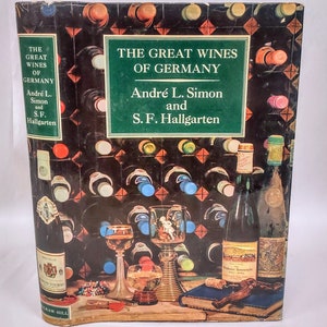 May include: A book cover with a green background and the title "The Great Wines of Germany" by Andre L. Simon and S.F. Hallgarten. The cover features a still life of wine bottles, glasses, and a corkscrew.