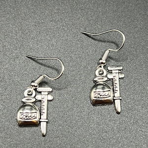 Medication vial with syringe earrings