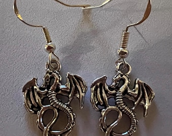 Peut inclure: Une paire de boucles d'oreilles en argent en forme de dragon avec des ailes détaillées et une queue enroulée.