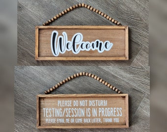 May include: Two wooden signs with a beaded string for hanging. The top sign says "Welcome" in white lettering. The bottom sign says "Please do not disturb! Testing/Session is in progress. Please email me or come back later, thank you."