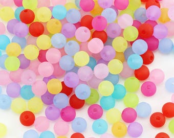 May include: A collection of colorful, round beads in various shades of red, pink, yellow, green, purple, and blue. The beads are scattered, creating a vibrant and playful display. These beads are suitable for jewelry making and craft projects.