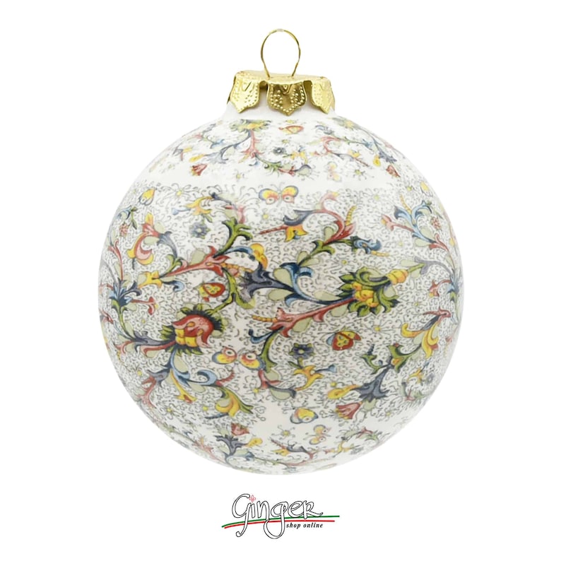 May include: A white ceramic Christmas ornament with a gold top and a colorful floral pattern.