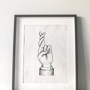 Pode incluir: Uma ilustração em preto e branco de uma mão com o dedo indicador cruzado sobre o dedo médio. A mão é desenhada em estilo vintage e está emoldurada em uma moldura preta.