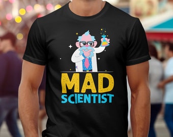 May include: Black t-shirt with a cartoon illustration of a mad scientist in a white lab coat, glasses, and a colourful beard, holding a flask. The text "MAD SCIENTIST" is in yellow and blue.