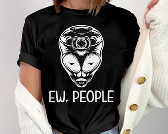 May include: Black t-shirt featuring a white alien head graphic with the text "EW, PEOPLE." The alien design has large eyes and a detailed headpiece. A casual, everyday wear tee.