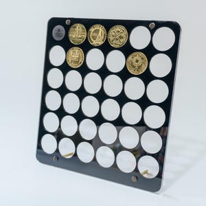 May include: Black acrylic coin display stand with 36 circular slots for coins. The stand has a gold metal base and is holding several gold coins with different designs.