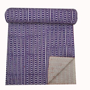 May include: Purple and white kantha quilt with a striped and dotted pattern. The quilt is folded in half and rolled up.