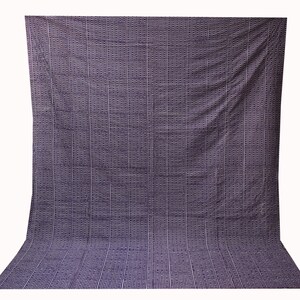 May include: A large, dark purple fabric backdrop with a repeating pattern of small white squares.