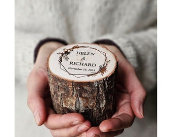 May include: A wooden ring box with a geometric design and floral accents. The box is engraved with the names "Helen & Richard" and the date "November 23, 2023".