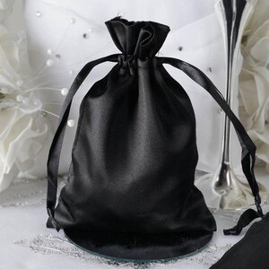 May include: A black satin drawstring bag with a satin ribbon closure. The bag is empty and ready to be filled with gifts or favors.
