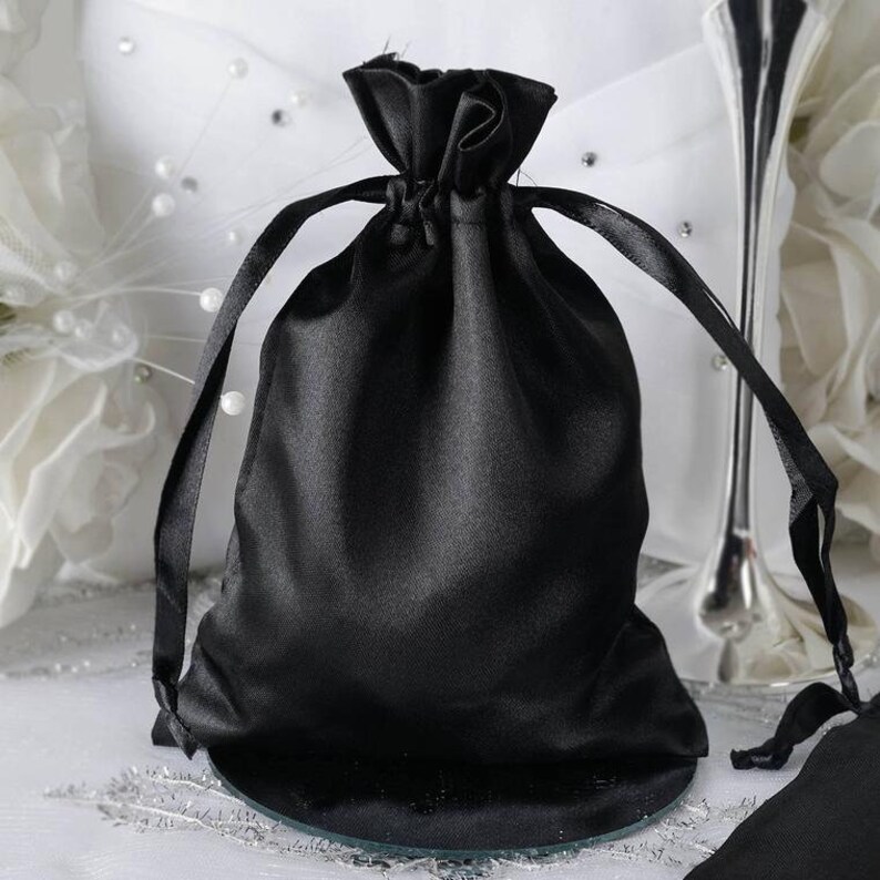 May include: A black satin drawstring bag with a satin ribbon closure. The bag is empty and ready to be filled with gifts or favors.