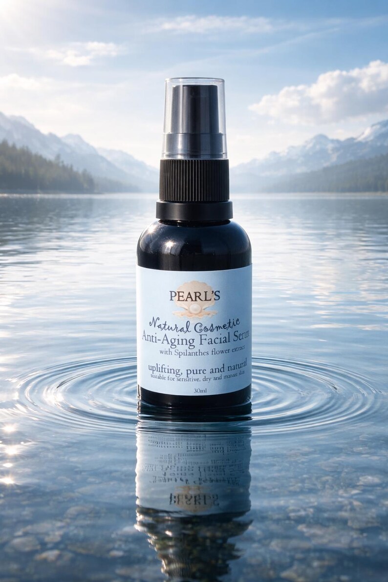 May include: A black bottle of Pearl's Natural Cosmetic Anti-Aging Facial Serum with a spray nozzle. The label includes the text "uplifting, pure and natural". The bottle is reflected in the water, with mountains in the background.
