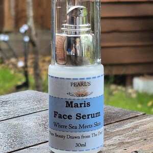 May include: A clear glass bottle of Maris Face Serum with a silver pump dispenser. The label features the text "PEARL'S Natural Cosmetic" and "Where Sea Meets Skin". The bottle contains 30ml of product.