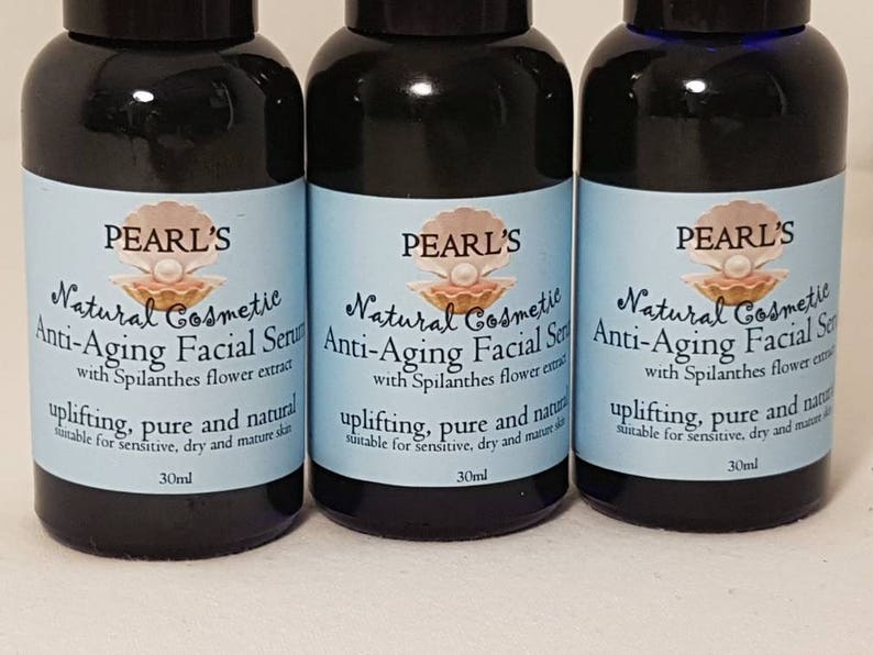 May include: Three dark blue glass bottles of Pearl's Natural Cosmetic Anti-Aging Facial Serum. Each bottle has a light blue label with a pearl and shell logo, and text that reads "uplifting, pure and natural" and "30ml".