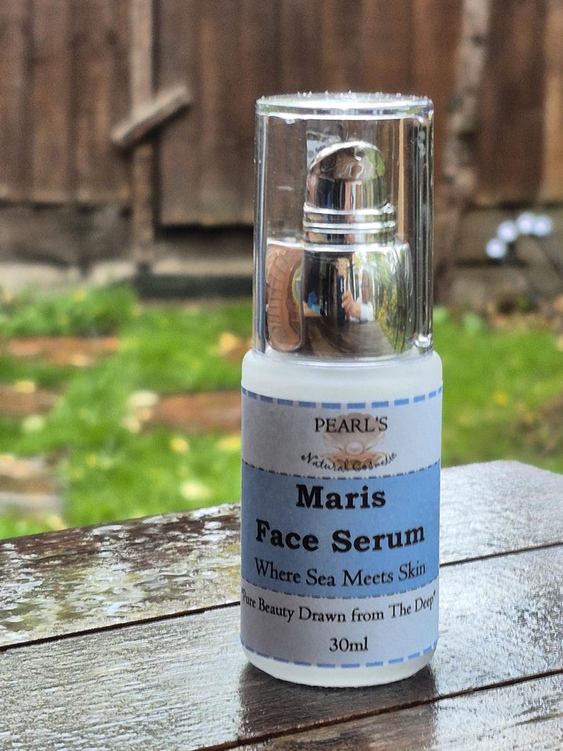 May include: A clear glass bottle of Maris Face Serum with a silver pump top. The label is white and light blue, with the text "PEARL'S Natural Care" and "Where Sea Meets Skin". The bottle contains 30ml of product.