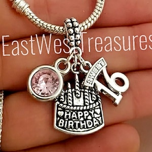May include: Silver charm bracelet with a pink crystal, a cake charm with the text "Happy Birthday", a charm with the number "16" and the text "Sweet 16".