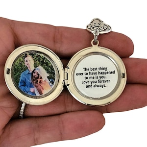 May include: Silver locket necklace with a heart-shaped bail. The locket opens to reveal a photo of a couple and a message inside that reads: "The best thing ever to have happened to me is you. Love you forever and always."
