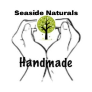 May include: A black and white illustration of two hands forming a heart shape around a green tree with the text "Seaside Naturals Handmade" below.