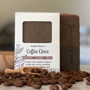 May include: A brown bar of soap with the text "Seaside Naturals - Coffee Clove" on the label. The soap is surrounded by coffee beans and a wooden scoop.