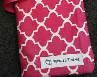 Puede incluir: Una bolsa de tela rosa con un patrón geométrico blanco y una etiqueta blanca que dice "POCKETS & THREADS". La bolsa está atada con una cinta rosa.