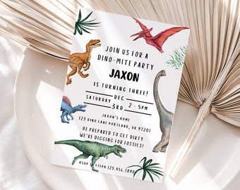 May include: A white dinosaur party invitation with colorful dinosaur illustrations. The invitation reads "Join us for a Dino-mite party Jaxon is turning three! Saturday Dec 5th 2-5pm Jason's Home 125 Dino Lake Portland, OR 97201 Be prepared to get dirty we're digging for fossils!"