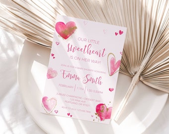 May include: Pink and gold baby shower invitation with the text "Our Little Sweetheart is on her way!"  Join us for a baby shower honoring Emma Smith, February 11th, 1:30-3:30pm.  Jubilee Champagne & Dessert Bar, 125 Pine Ave, Portland, OR 97201.
