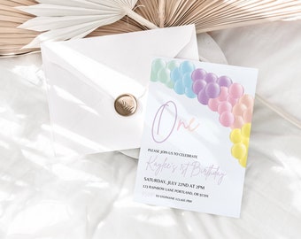 May include: A white invitation card with a pastel rainbow balloon arch and the text "One" in pink. The text "Please join us to celebrate Kayke's 1st Birthday" is written in cursive. The date and time of the event are listed below, along with the address and phone number.