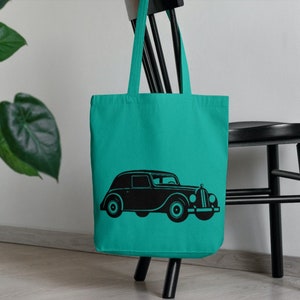May include: A turquoise tote bag with a black silhouette of a vintage car printed on the front.