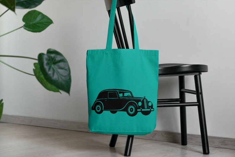 May include: A turquoise tote bag with a black silhouette of a vintage car printed on the front.