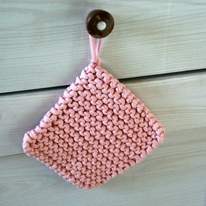 Op de afbeelding: Een roze gebreide ovenwant met een lus om op te hangen.