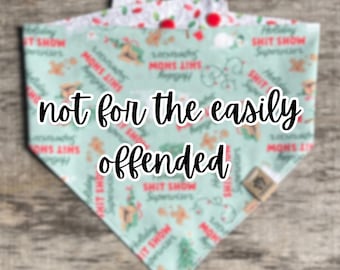 May include: A triangular pet bandana with the text "not for the easily offended" in a bold, black font. The bandana has a light teal background with a repeating pattern of holiday-themed graphics and text.