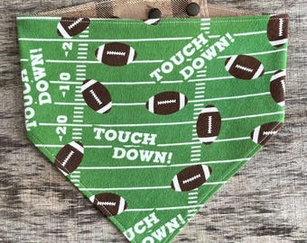May include: Green and brown football-themed bandana with the words "Touch Down!" repeated on a green field with white yard lines and brown footballs.