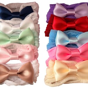May include: A selection of baby headbands in assorted colours. Each headband has a satin bow on a ruffled fabric band. Colours include navy, white, mint green, pink, and tan. Additional headbands in purple, red, light blue, and yellow.
