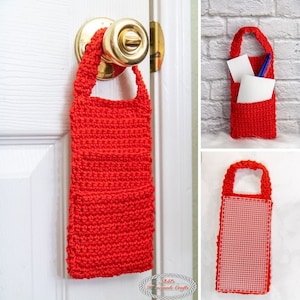 May include: A bright red crocheted door hanger with a pocket for holding small items. The hanger is hanging on a white door with a gold door knob.