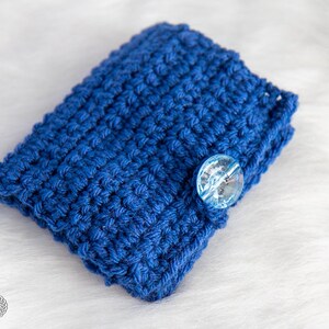 Pu&ograve; includere: Una pochette in crochet blu con un bottone trasparente. La pochette &egrave; realizzata con un punto a trama e perfetta per riporre piccoli oggetti.