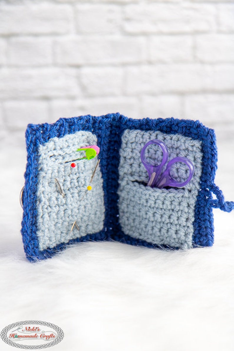 Pu&ograve; includere: Un porta aghi e forbici in crochet blu con due scomparti. Uno scomparto contiene una variet&agrave; di aghi da cucito e l'altro scomparto contiene un paio di forbici viola.