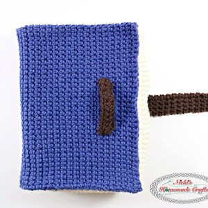 Pode incluir: Uma bolsa de tecido azul de malha com uma al&ccedil;a de malha marrom. A bolsa est&aacute; parcialmente aberta, revelando um forro de tecido branco de malha.