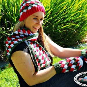 May include: A handmade crochet hat, scarf, and mittens set in red, white, and green. The set features a textured pattern and is displayed outdoors. The set is perfect for cold weather and adds a festive touch.