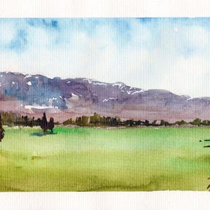 Può includere: Dipinto di paesaggio ad acquerello raffigurante una catena montuosa sotto un cielo nuvoloso. Il primo piano presenta un campo verde con alcuni alberi. Il dipinto utilizza sfumature di blu, verde, viola e marrone.