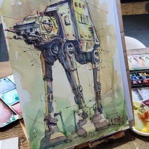 May include: Watercolor painting of a yellow and brown AT-AT walker, a fictional vehicle from the Star Wars franchise. The painting is on a white canvas and is set on an easel.