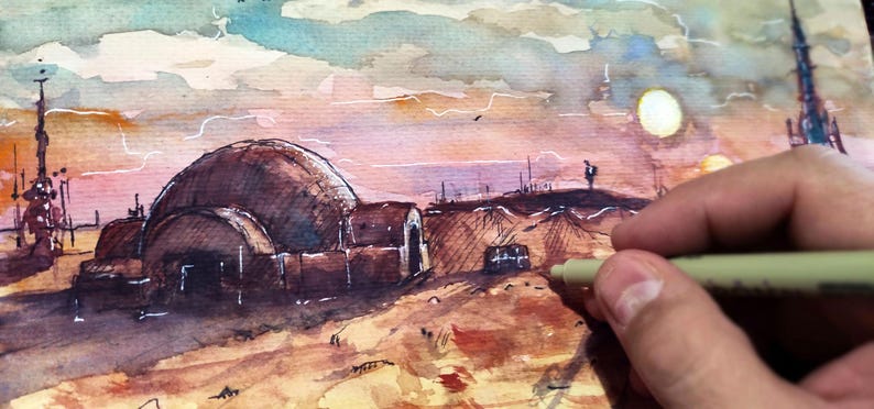 Op de afbeelding: Aquarel schilderij van een woestijnlandschap met koepelvormige structuren en hoge torens onder een zonsonderganghemel. Een hand die een pen vasthoudt, staat op de voorgrond en voegt details toe aan het kunstwerk. De sc&egrave;ne roept een sciencefictionthema op.