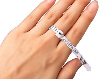 May include: White plastic ring sizer with a numbered scale from 2 to 17. The sizer is wrapped around a finger to determine ring size. The text "PAT. PEND. 9101693" is printed on the sizer.