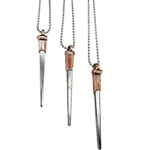 May include: Three silver and copper pendant necklaces with a pointed, dagger-like design. The necklaces are on a black chain.