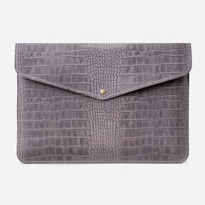 May include: A gray leather laptop sleeve with a crocodile embossed pattern and a gold button closure.