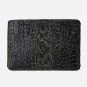K&ouml;nnte beinhalten: Eine dunkelgr&uuml;ne Laptoptasche aus Leder mit einem krokodilgepr&auml;gten Muster.