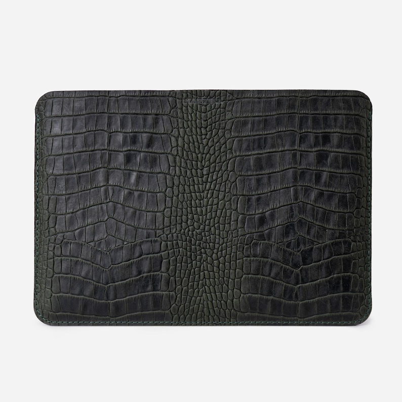 K&ouml;nnte beinhalten: Eine dunkelgr&uuml;ne Laptoptasche aus Leder mit einem krokodilgepr&auml;gten Muster.