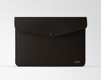 May include: A black leather envelope with a flap closure and a single button. The envelope has the initials "LPV" embossed in gold on the front.